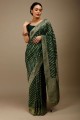 banarasi silk party wear saree avec zari, tissage, bordure en dentelle en vert foncé